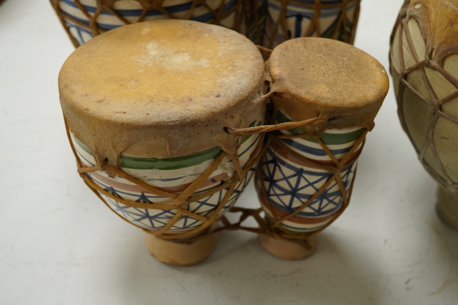 Five African drums; a Djembe, 60cm high, together with four small North African pottery double drums. Condition - fair to good.